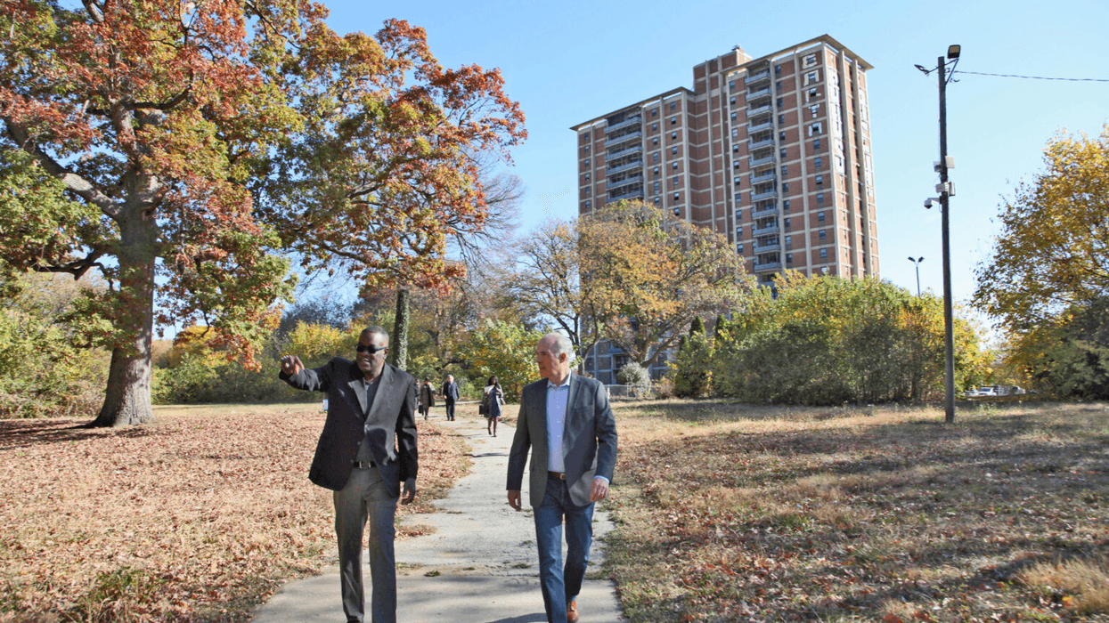 Former U.S. Sen. Bob Casey and Philadelphia Housing Authority President Kelvin Jeremiah walk the campus of Westpark Apartments, a public housing site that is being updated into modern, affordable housing.