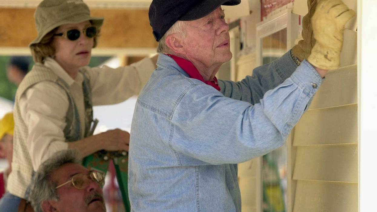 Former US President Jimmy Carter and former First Lady Rosalyn Carter attach siding to the front of a Habitat for Humanity home being built June 10, 2003 in LaGrange, Georgia.