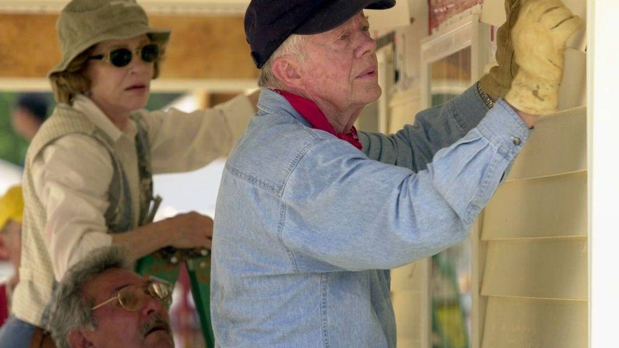 Former US President Jimmy Carter and former First Lady Rosalyn Carter attach siding to the front of a Habitat for Humanity home being built June 10, 2003 in LaGrange, Georgia.