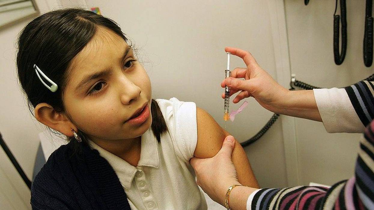 Fourth-grader Arylu Paniagua, 9, receives an immunization shot from registered nurse Patricia McGleam in the Loyola Pediatric Mobile Health Unit.
