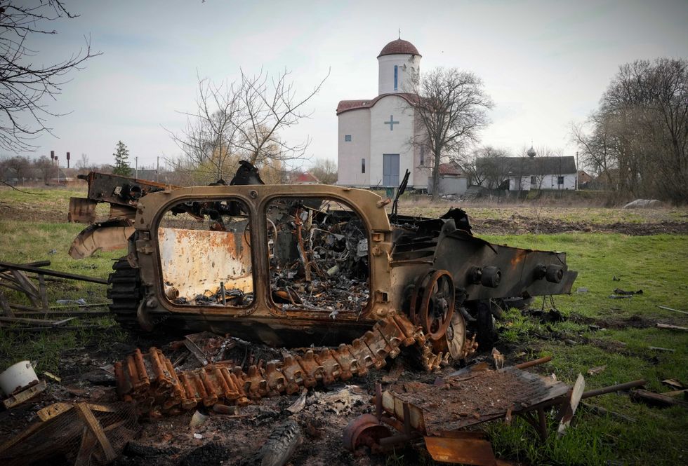 Fragments of a destroyed Russian military vehicle lie against the background of an Orthodox church in the village of Lypivka close to Kyiv, Ukraine, Monday, Apr. 11, 2022