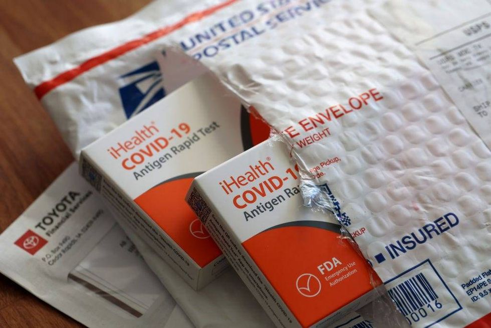 free iHealth COVID-19 antigen rapid tests from the federal government sit on a U.S. Postal Service envelope after being delivered on February 04, 2022 in San Anselmo, California.