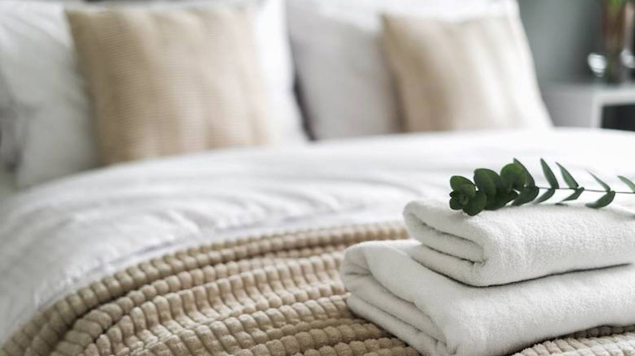 Fresh, folded towels on a hotel bed