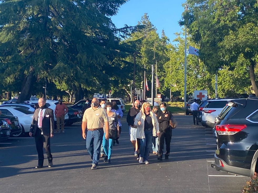 Friends and family of victims in the San Jose VTA shooting being escorted out of the Red Cross building on Wednesday night.