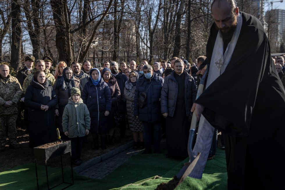 Friends and family watch on as Captain Anton Olegovich Sidorov is laid to rest during his funeral ceremony on February 22, 2022 in Kyiv, Ukraine