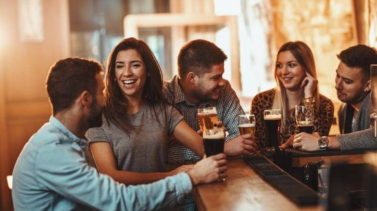 Friends drinking and talking sitting at a bar