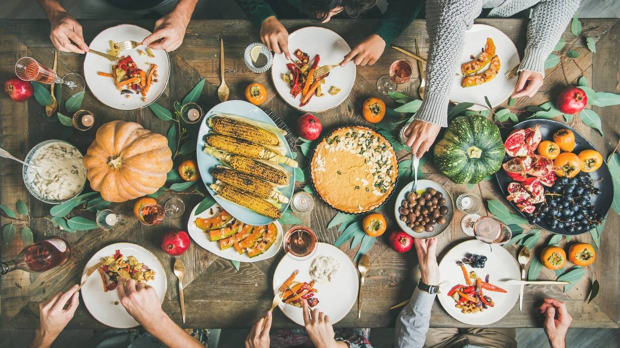 Friends eating at Thanksgiving Day table with vegetarian meals