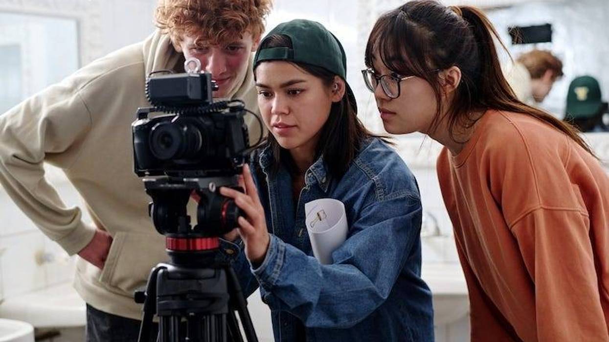 Friends setting up a camera while filming a project