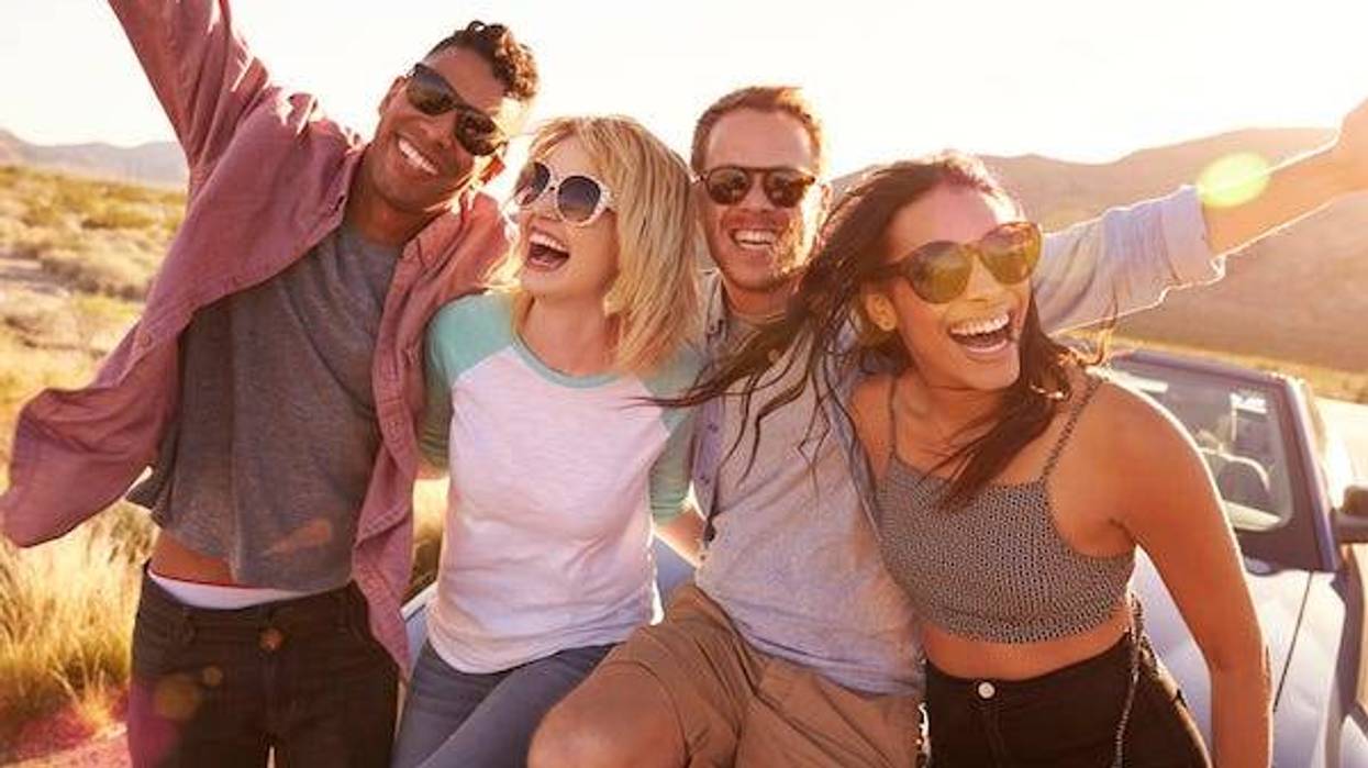 Friends sitting on the hood of a car