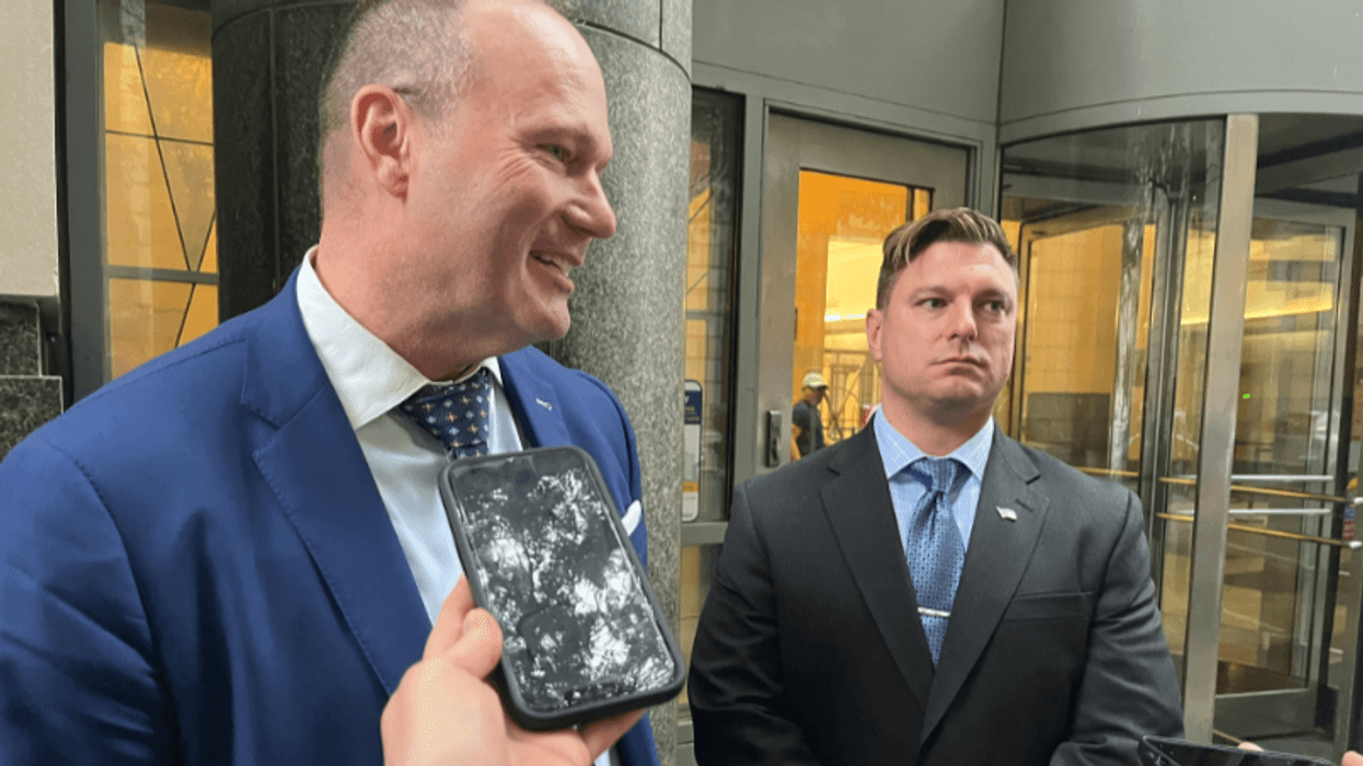 From left: Defense attorney Coley Reynolds and former Philly cop Darren Kardos pause for reporters outside of the Center for Criminal Justice.