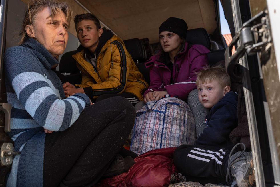From left to right, Oksana Gavrielutca 41, sits at the back of a bus with her children Oleg 18, Diana 17 and Vlad 5 after they flee from Snigiriovka village, in Mikolaiv district, Ukraine, on Thursday, April 7, 2022