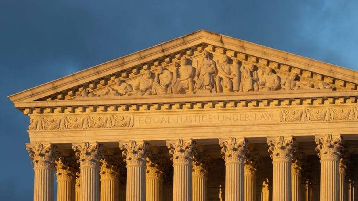 Front view of the Supreme Court Building in Washington, DC, against a dramatic stormy sky during sunset.