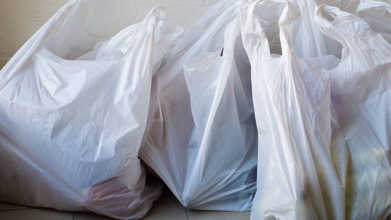 full plastic shopping bags on tiled floor