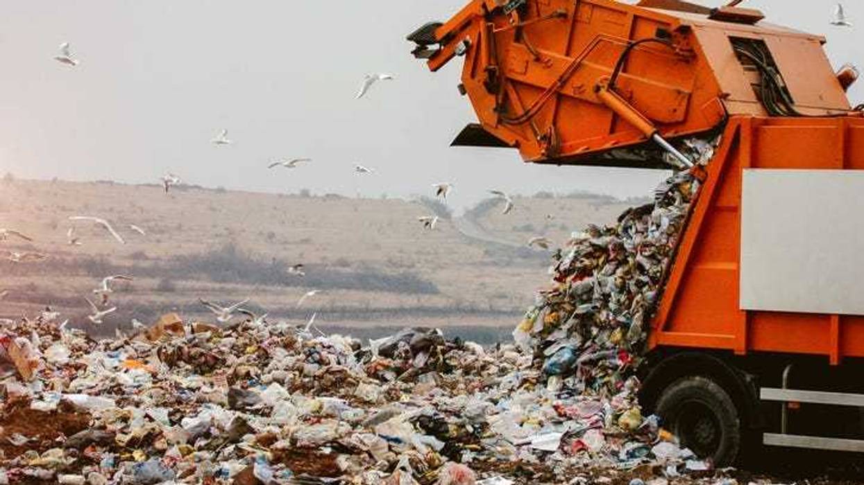 Garbage truck dumping waste into a landfill.