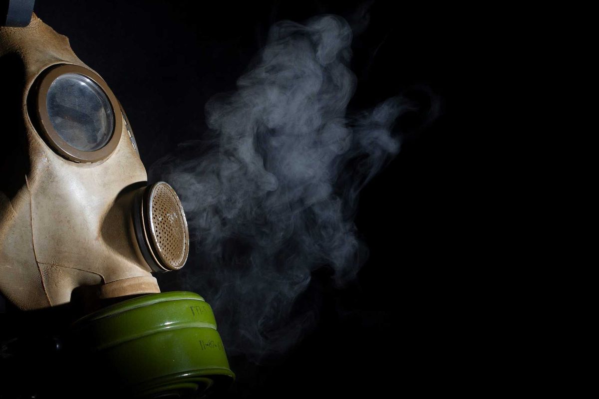Gas mask with smoke in the background.