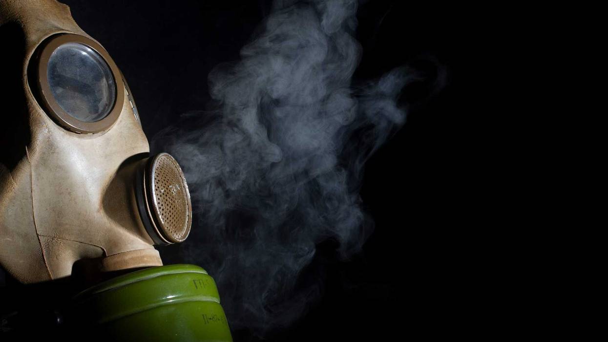 Gas mask with smoke in the background.