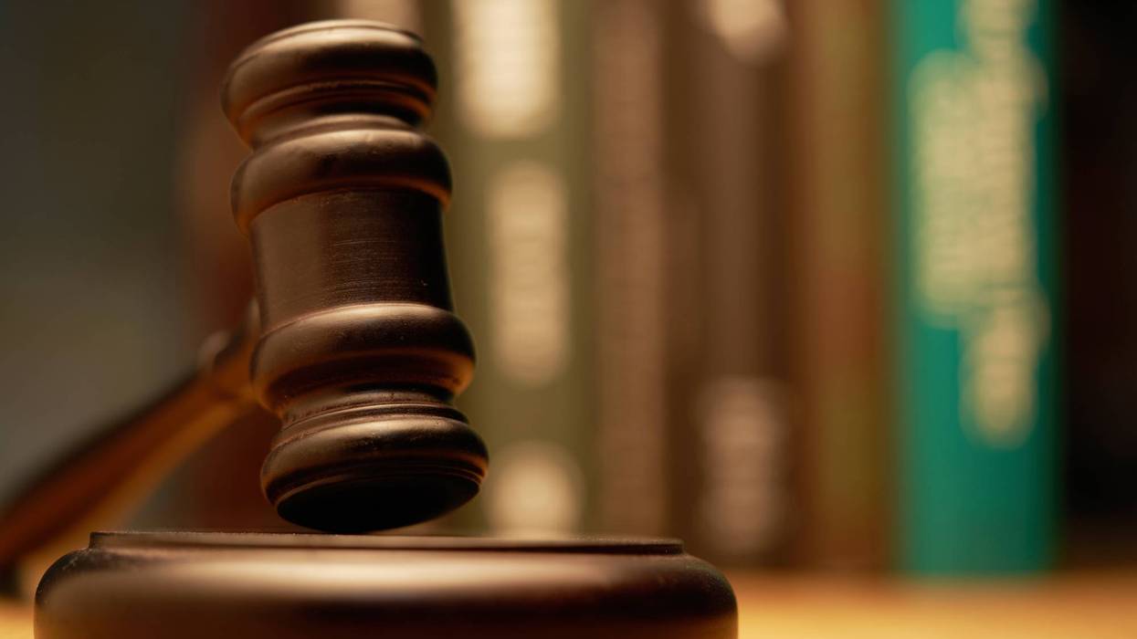 Gavel on wooden desk with books as background