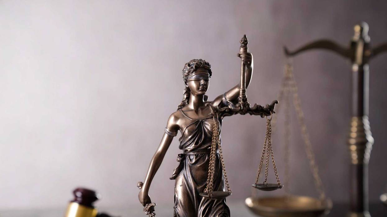 Gavel, scale and Themis sculpture on the gray background.