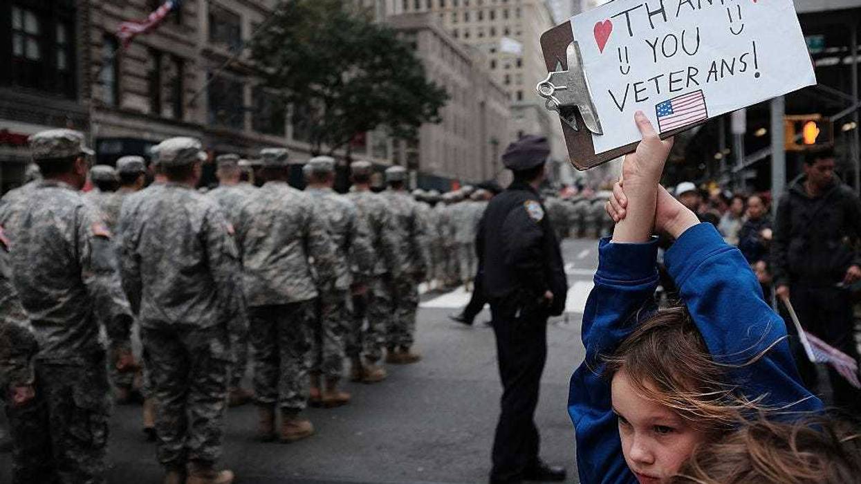 Gavin Kinney (9) holds up a sign thanking veterans at the nation's largest Veterans Day Parade in New York City on November 11, 2015 in New York City. Known as "America's Parade" it features over 20,000 participants, including veterans of numerous eras, military units, businesses and high school bands and civic and youth groups. (Photo by Spencer Platt/Getty Images)