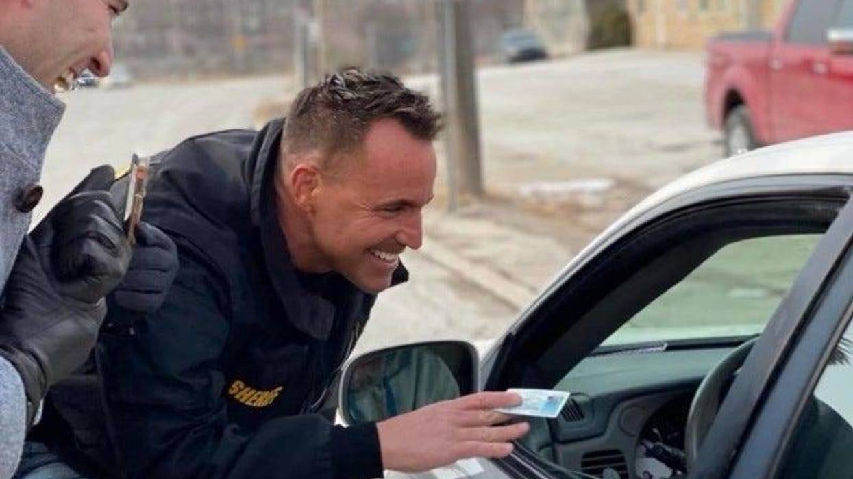Genesee County Sheriff Chris Swanson handing gift card to driver