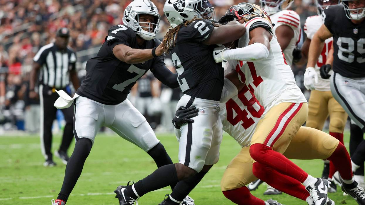 Geno Smith #7 of the Las Vegas Raiders pushes Ashton Jeanty #2 past Tatum Bethune #48 and Ji'Ayir Brown #27 of the San Francisco 49ers while Jeanty scores a rushing touchdown during the second quarter of the NFL Preseason 2025 game at Allegiant Stadium on August 16, 2025 in Las Vegas, Nevada.