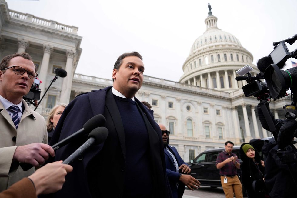 George Santos is surrounded by journalists as he leaves the U.S. Capitol after his fellow members of Congress voted to expel him from the House of Representatives on Dec. 1, 2023