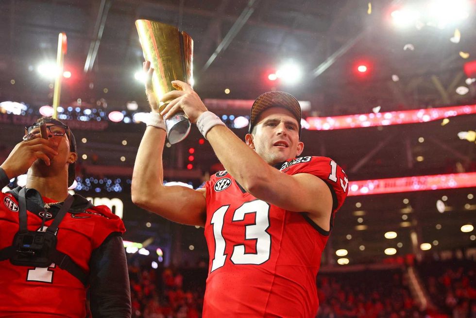 Georgia Bulldogs quarterback Stetson Bennett (13) holds the trophy after winning the CFP national championship game against the TCU Horned Frogsat SoFi Stadium.
