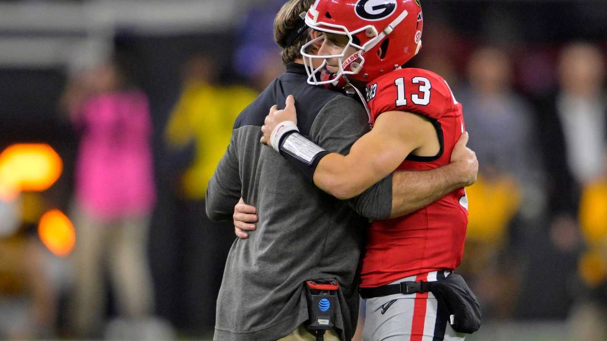Georgia Bulldogs quarterback Stetson Bennett (13) is greeted by head coach Kirby Smart as he comes out of the game in the 4th quarter against the TCU Horned Frogs in the CFP national championship game at SoFi Stadium.