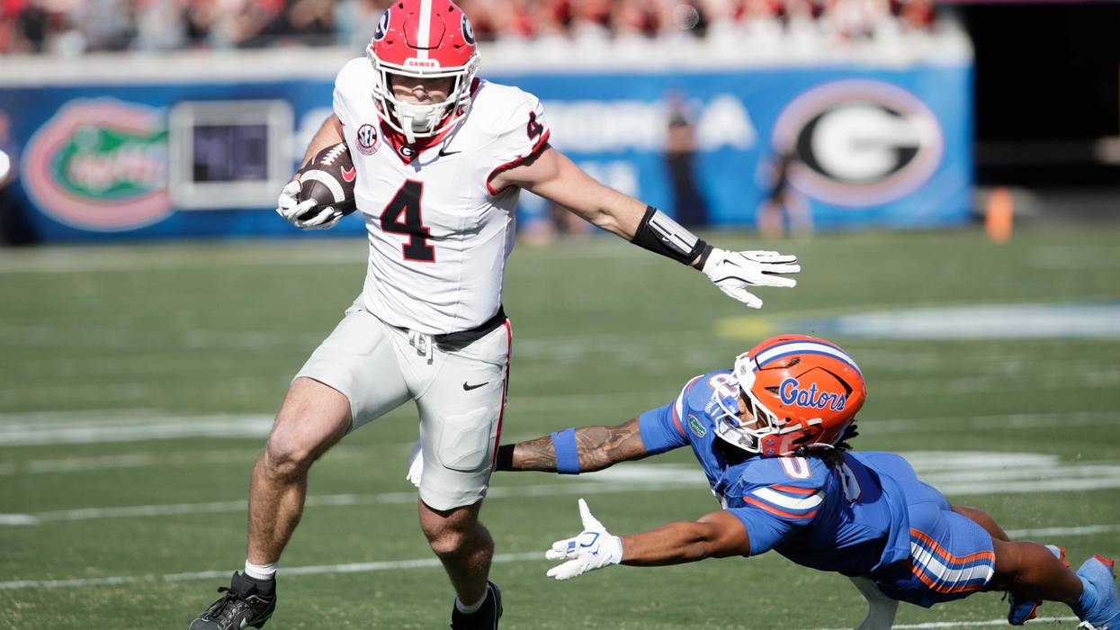 Georgia Bulldogs tight end Oscar Delp (4) evades Florida Gators defensive back Sharif Denson (0) in the first quarter at EverBank Stadium.