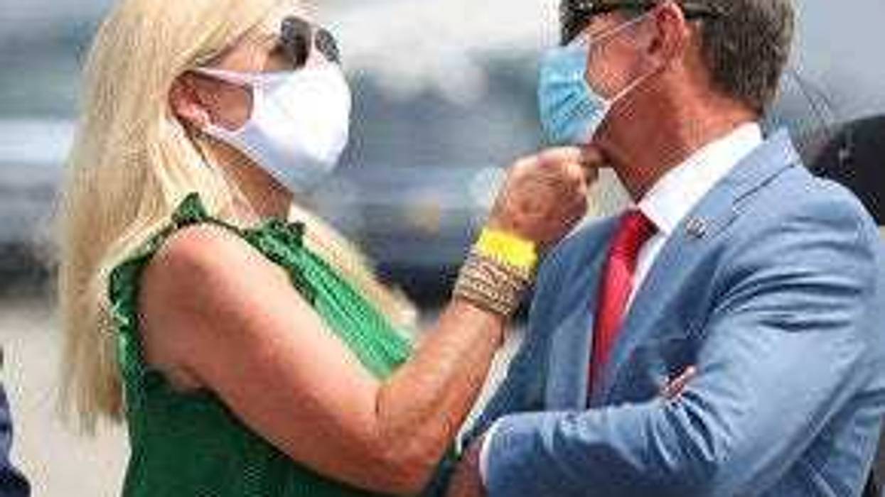 Georgia Gov. Brian Kemp has his mask adjusted by first lady Marty while waiting for President Donald Trump to arrive for his Georgia visit. (Curtis Compton/Atlanta Journal-Constitution via AP)