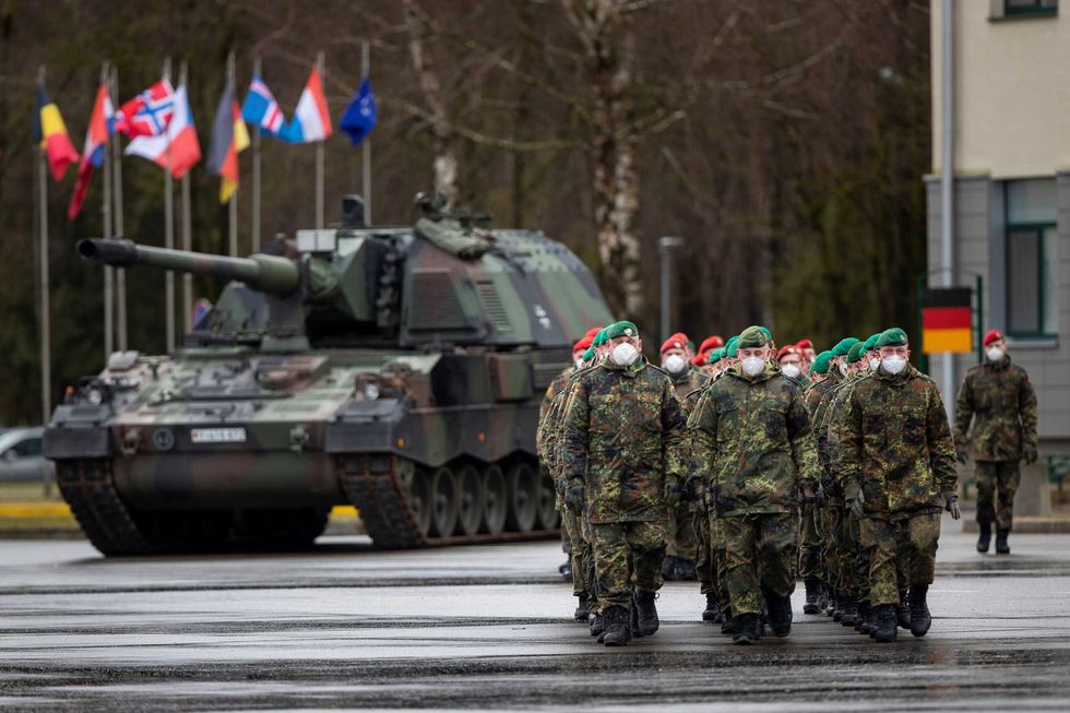 German Bundeswehr soldiers of the NATO enhanced forward presence battalion waits to greet German Defense Minister Christine Lambrecht upon his arrival at the Rukla military base some 62.12 miles west of the capital Vilnius, Lithuania, Tuesday, Feb. 22, 2022