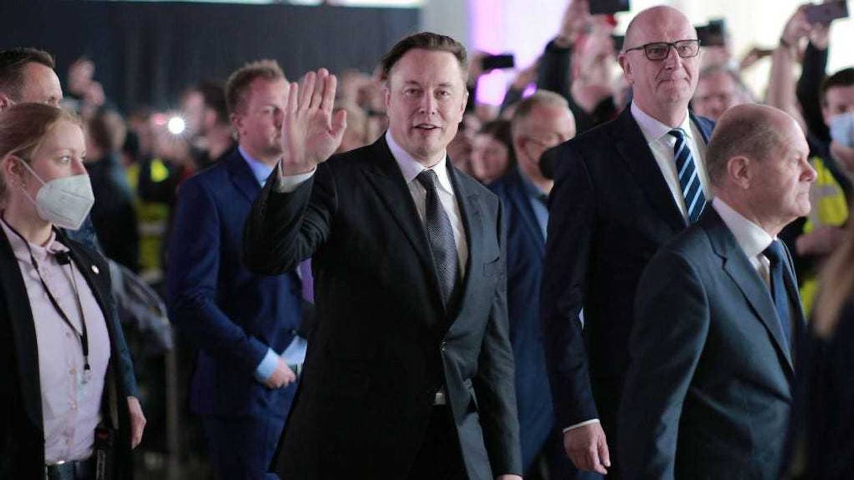German Chancellor Olaf Scholz (R), Brandenburg State Premier Dietmar Woidke (2ndR) and Tesla CEO Elon Musk (C) attend the official opening of the new Tesla electric car manufacturing plant on March 22, 2022 near Gruenheide, Germany.