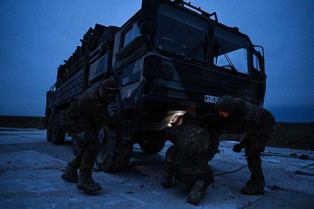 German soldiers search for a steel cable to pull out a M983 HEMTT mounted with a Patriot launcher module part of the US made MIM-104 Patriot surface-to-air missile (SAM) system from the mud on a open field on February 18, 2023 in Zamosc, Poland. The German armed forces deployed Patriots batteries to their NATO neighbor, after a missile explosion in Przewodow, which previous investigation suggests that came from Ukrainian air defense, killed two civilians. Since Russia's large scale military attack on Ukraine on February 24, 2022 more than 9.7 million refugees from Ukraine crossed the Polish borders to escape the conflict, with 1.4 million registering in Poland whilst others moved on to other countries. (Photo by Omar Marques/Getty Images)