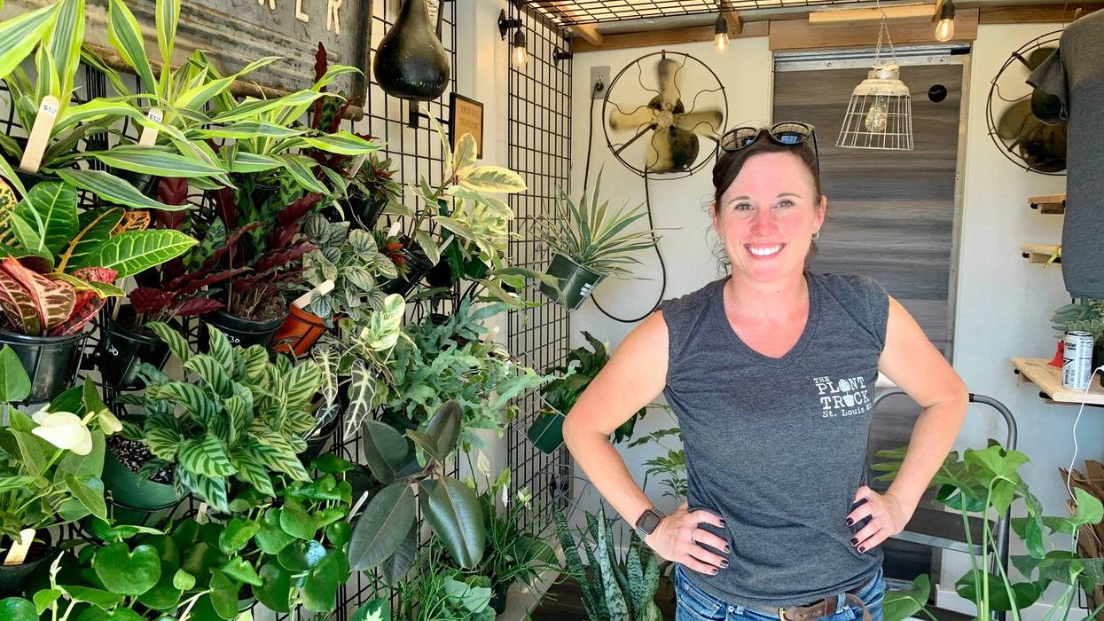Gina Marie Houska stands in front a wall of foliage in The Plant Truck