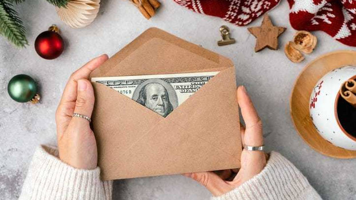 Girl counting US Dollar bills, wrapping in envelop. Top view Girl counting Christmas gifts. Woman hands doing budget, estimating money balance for shopping spree. Female accountant paying taxes.