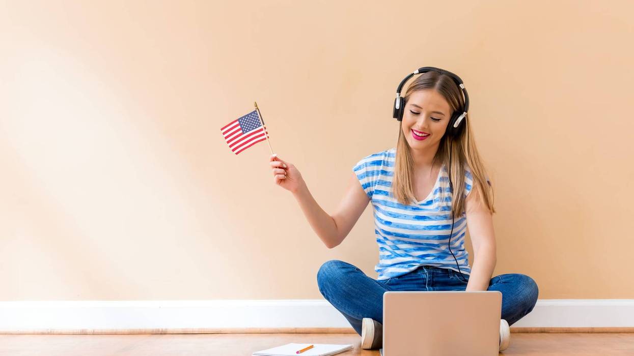 girl holding American flag with headphones on
