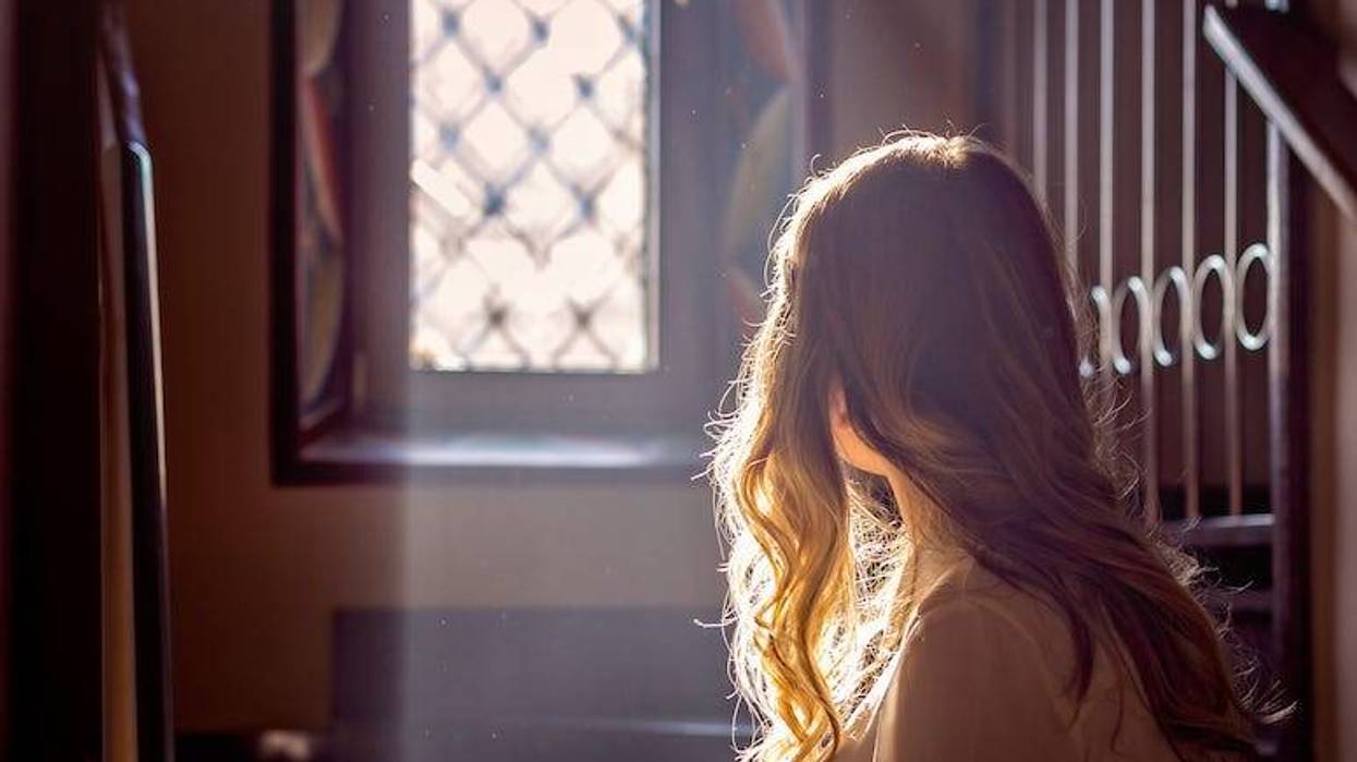 Girl looking out window of church
