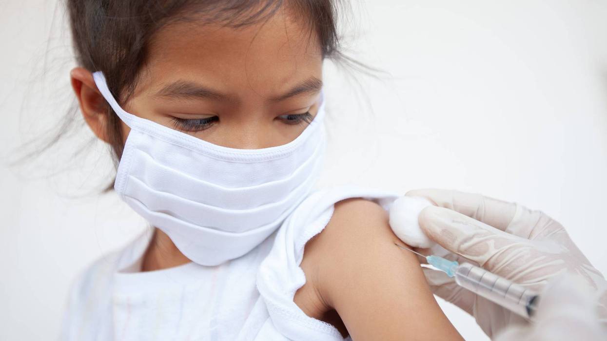 girl wearing face mask gets vaccine