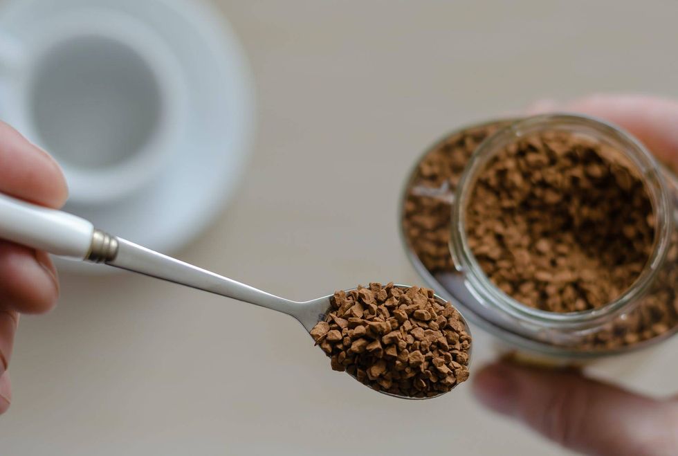 Glass jar with coffee in a hand
