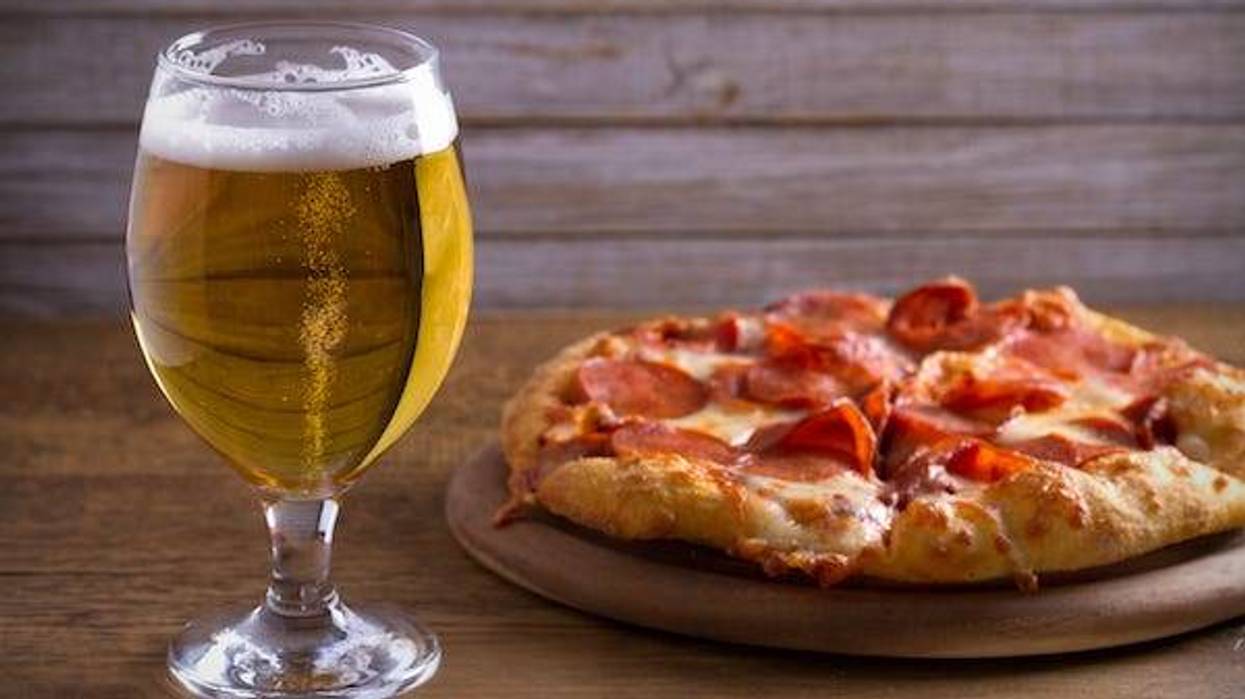 Glass of beer and a pizza on a wooden table