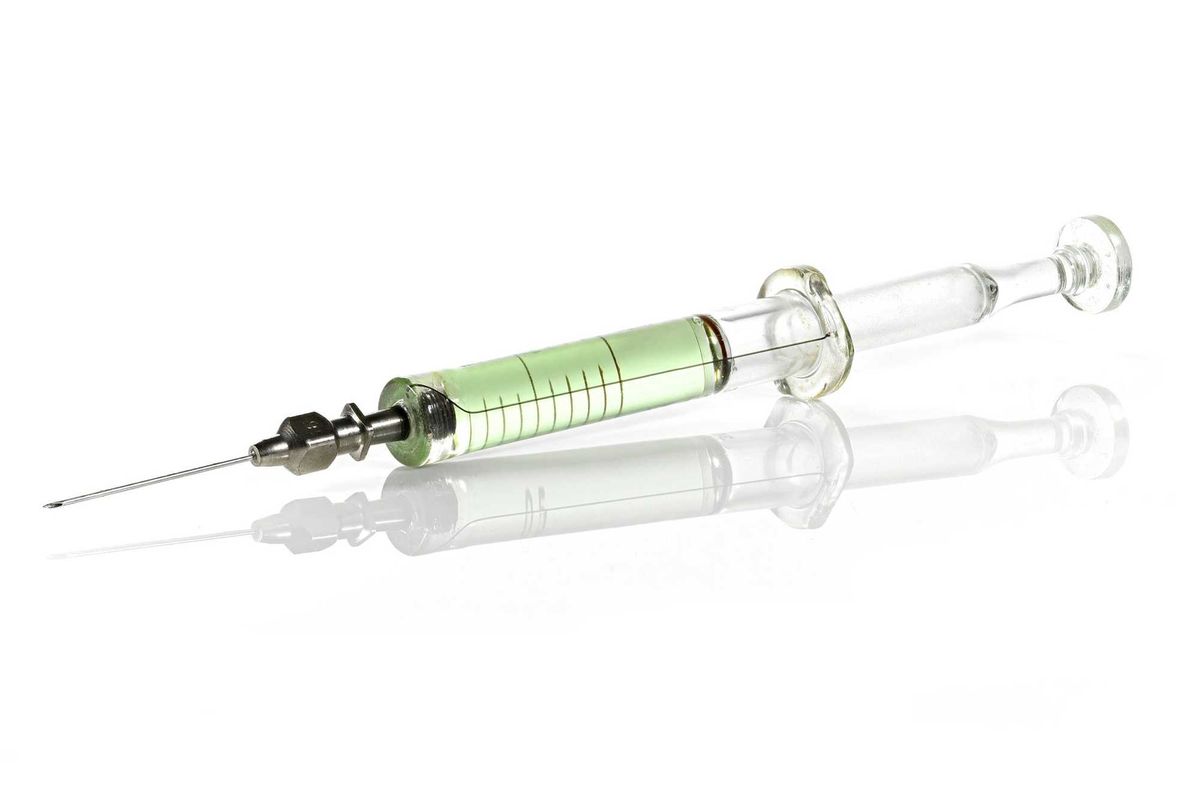 glass syringe filled with green liquid isolated on white background