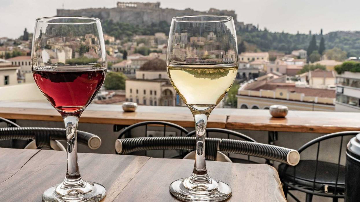 Glasses of wine with a view of the Acropolis in Athens, Greece.