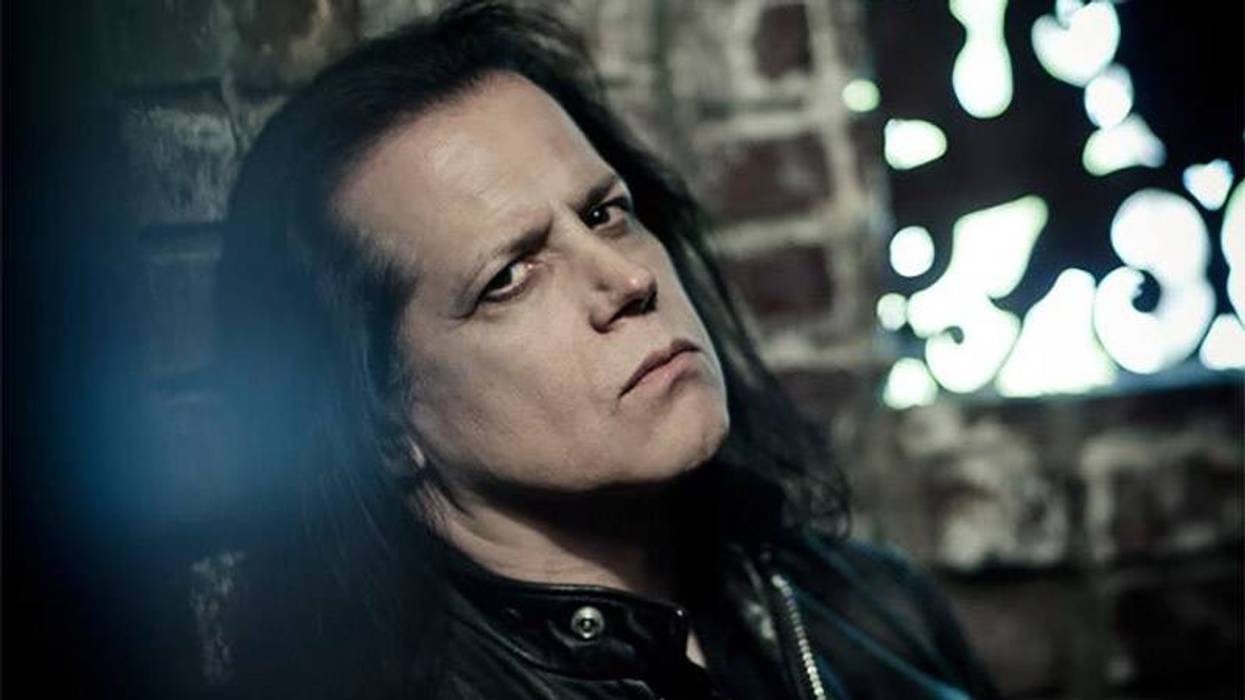 Glenn Danzig, long dark hair, leather jacket, stern expression.