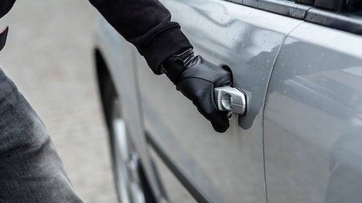 Gloved thief opening a car door