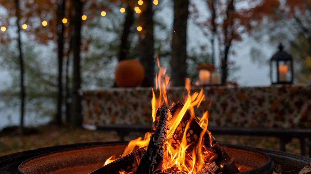 Glowing campfire at autumn campsite - stock photo