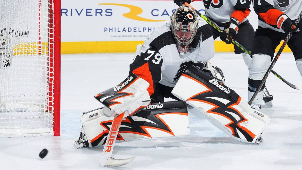 Goalie Carter Hart blocks a shot in front of the goal in Flyers uniform