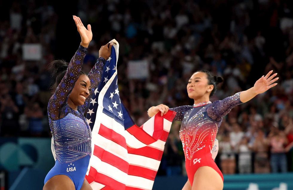 Gold medalist Simone Biles (L) and Bronze medalist Sunisa Lee of Team United States celebrate with the American flag after competing in the Artistic Gymnastics Women