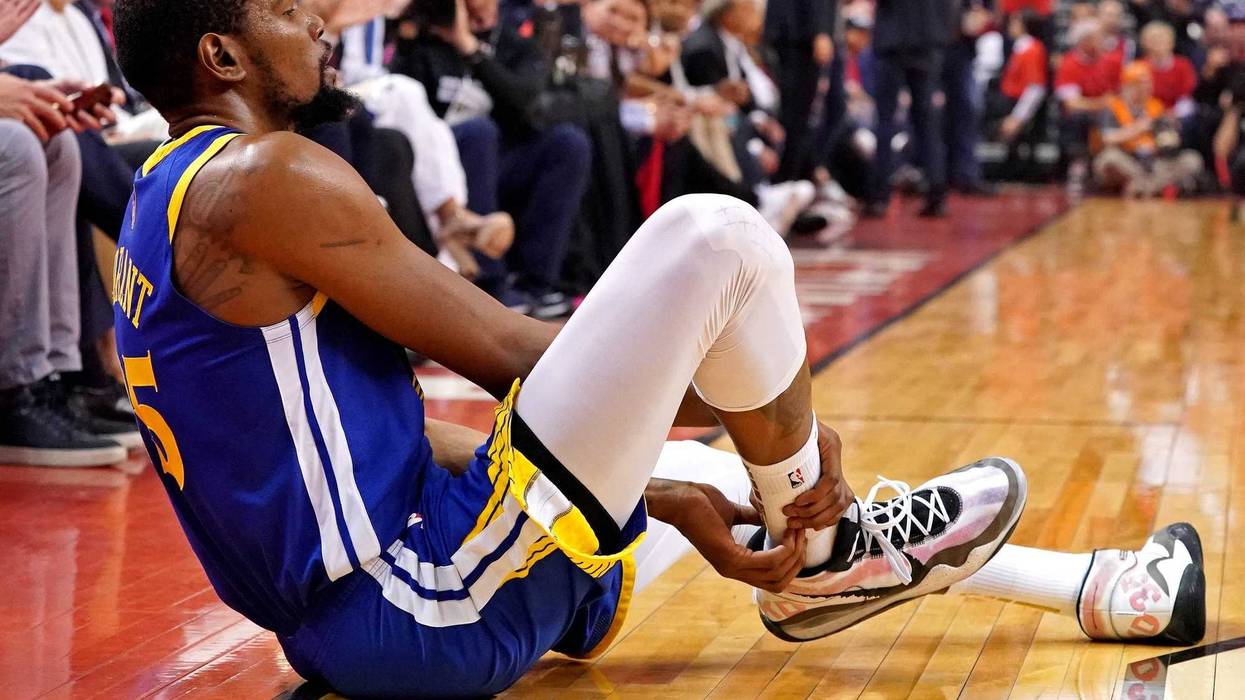 Golden State Warriors forward Kevin Durant (35) sits on the court after an apparent injury during the second quarter in game five against the Toronto Raptors of the 2019 NBA Finals at Scotiabank Arena.