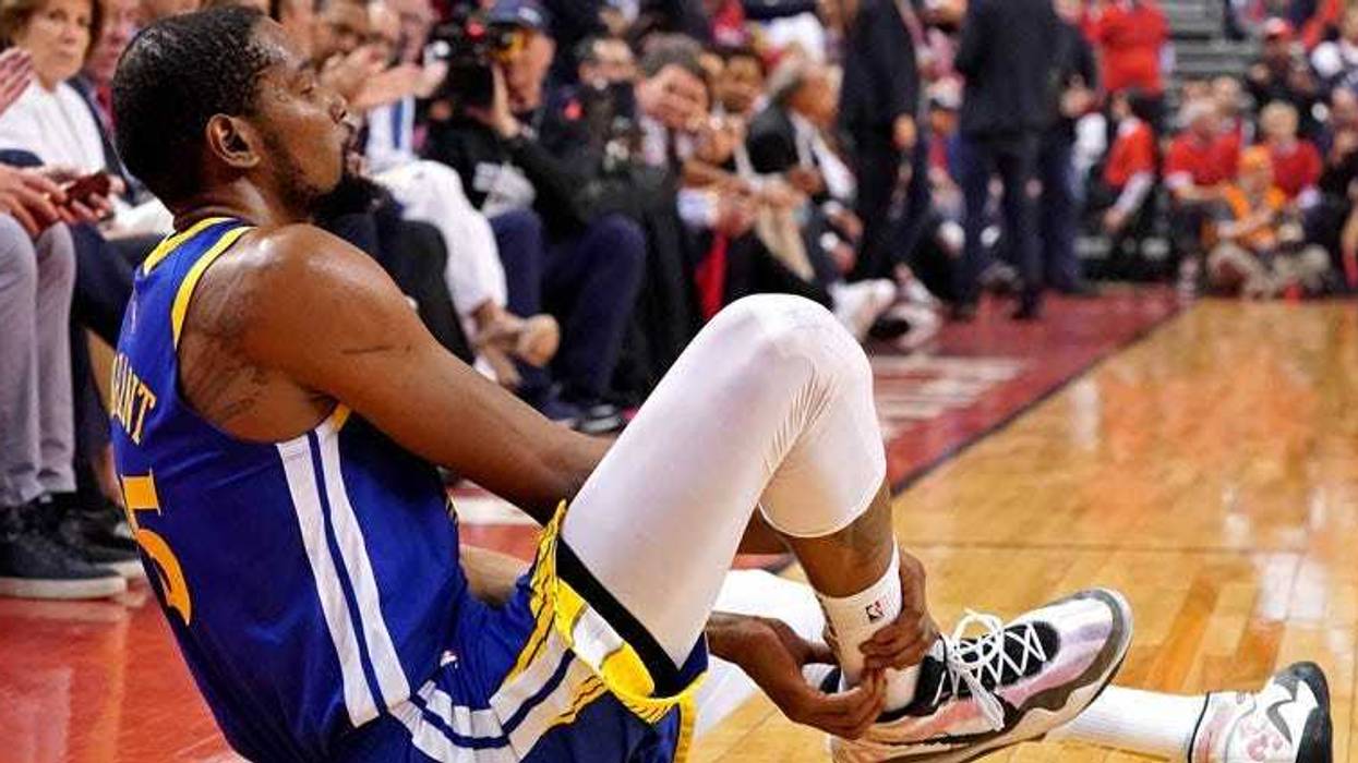 Golden State Warriors forward Kevin Durant sits on the court after an apparent injury in Game 5 of the NBA Finals against the Raptors on June 10, 2019, in Toronto.