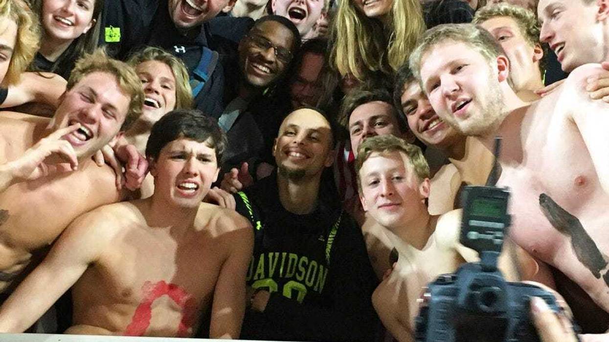 Golden State Warriors' Stephen Curry, center, poses with the Davidson College swim team as he takes in an NCAA college basketball game at his alma mater Friday, Feb. 15, 2019, while back in his hometown of Charlotte, N.C., for the NBA basketball All-Star